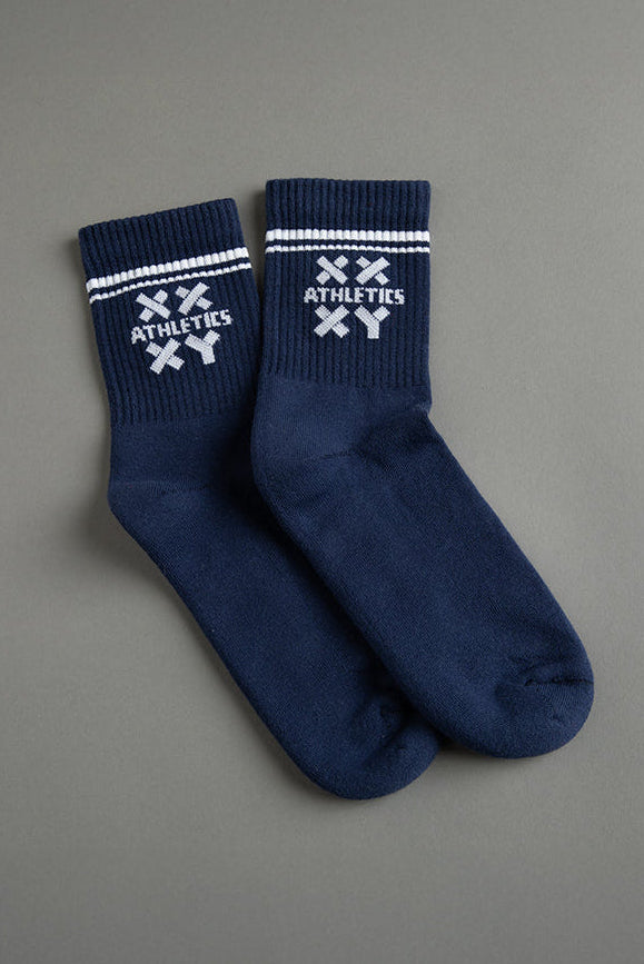 Pair of navy blue socks with white logo on a gray background || Navy