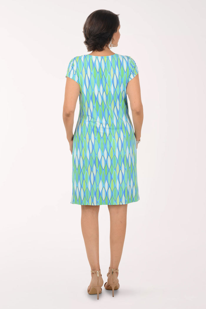 Woman wearing a green and blue patterned dress on a white background