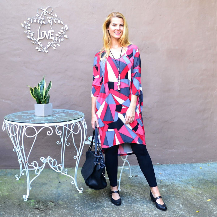 Patch work hi-low tunic dress by Four Girlz featuring colorful patchwork fabric and a relaxed, flowing silhouette.