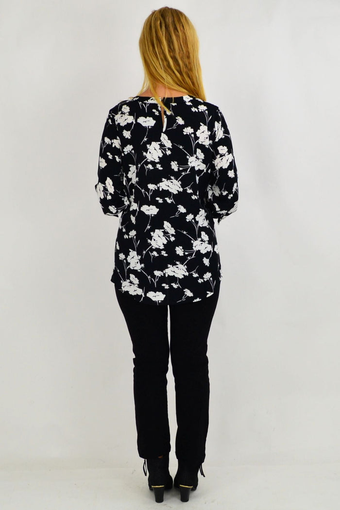 White flower print tunic by Envogo, with a relaxed fit and flowy fabric, displayed on a model.