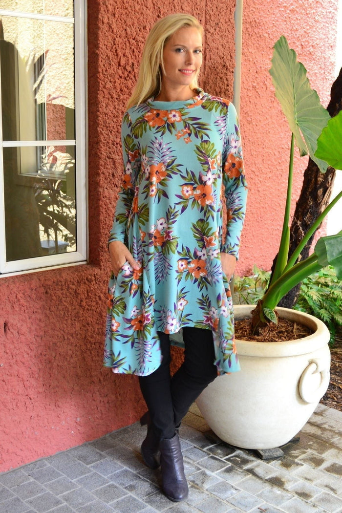 Aqua orange hibiscus fleece tunic dress by Hourglass featuring a loose fit, hibiscus print, and cozy fabric, shown on a mannequin.