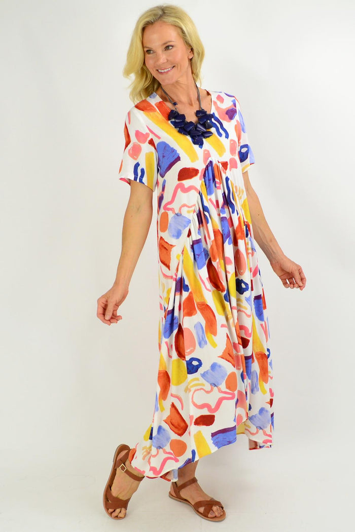 Artist Stock Maxi Tunic Dress from New U Collection, displayed on a hanger with a flowing, patterned fabric in natural light.