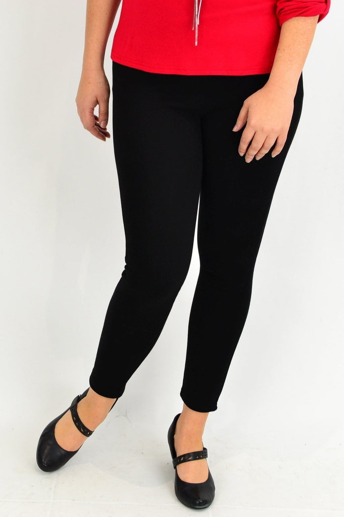 Black winter fleece-lined leggings by Whispers, showing close-up of soft fleece interior and stretchy black fabric exterior.