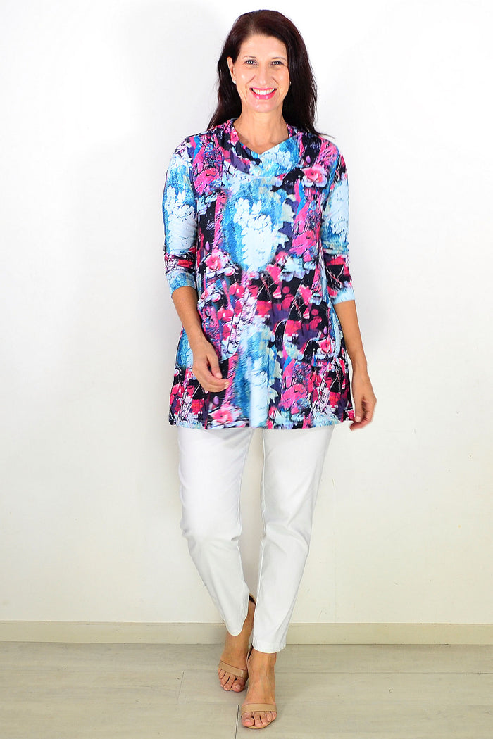 Blue floral leaves Wishstone tunic top with long sleeves and relaxed fit, displayed on a hanger against a neutral background.