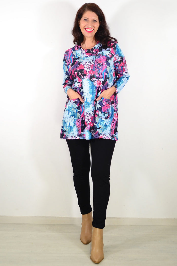 Blue floral leaves Wishstone tunic top with long sleeves and relaxed fit, shown on a hanger.