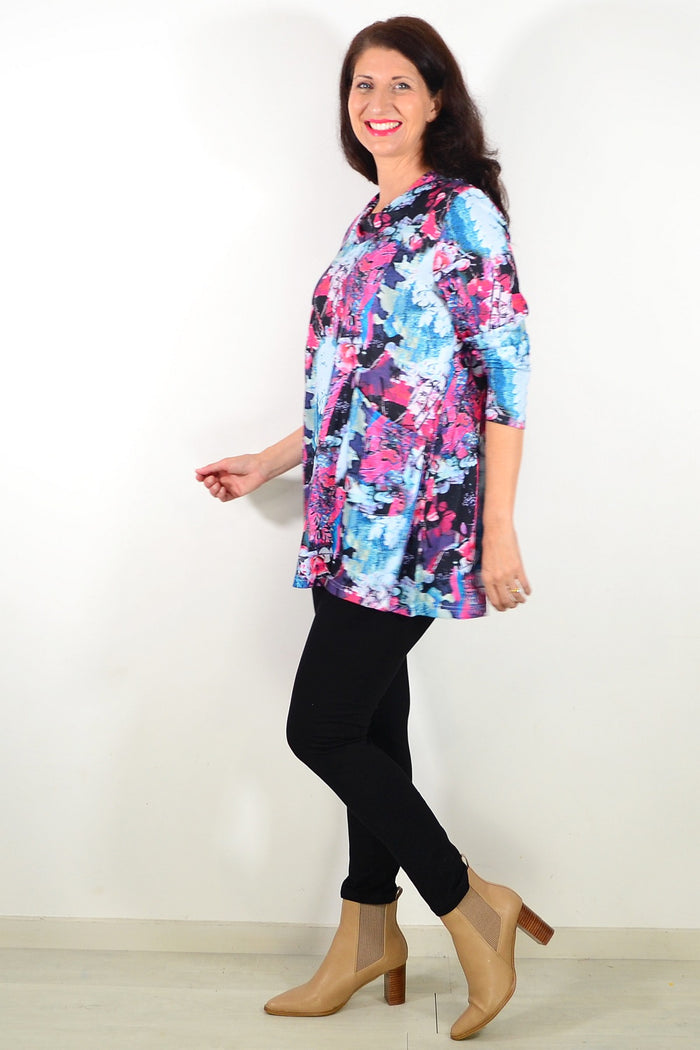 Blue floral leaves Wishstone tunic top with long sleeves and relaxed fit, displayed on a hanger against a neutral background.