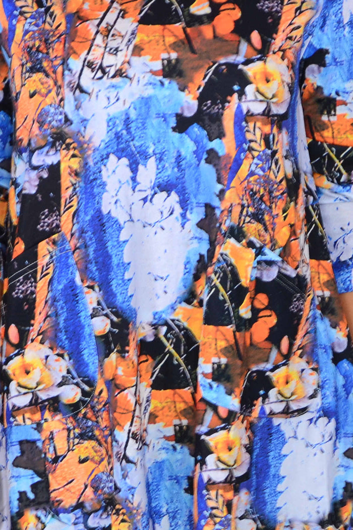 Blue orange floral print tunic top by Wishstone, featuring a relaxed fit and vibrant flower pattern, displayed on a hanger.