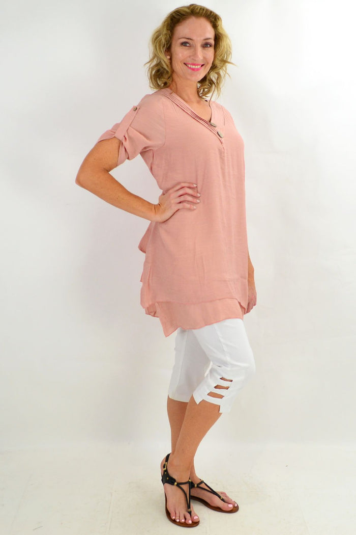 Blush coconut button short sleeve tunic top by La Mode, featuring a relaxed fit and front buttons, displayed on a hanger.