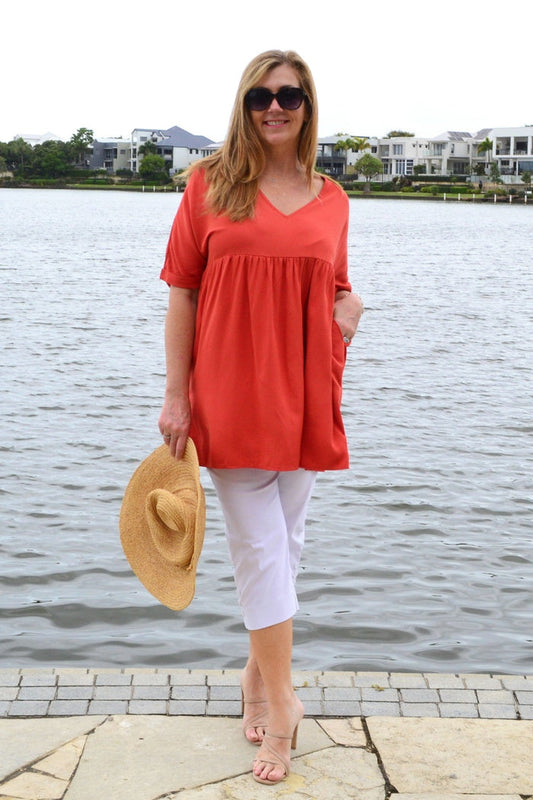 Burnt orange beach day tunic top by HQ featuring lightweight fabric and relaxed fit, shown on a hanger against a neutral background.