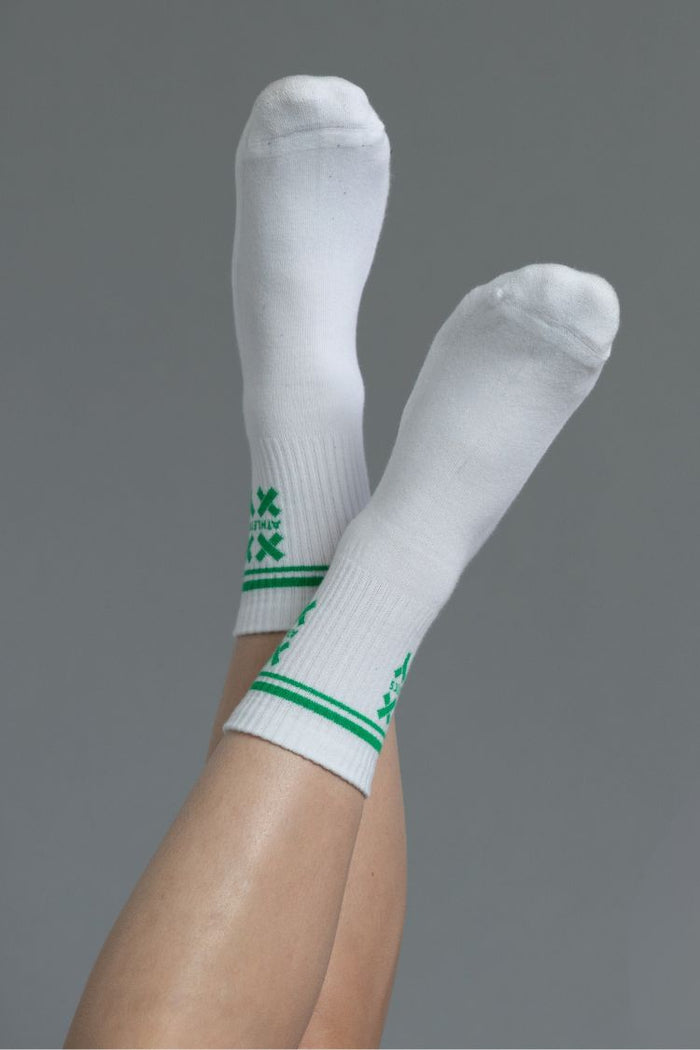 White socks with green stripes on a gray background || white