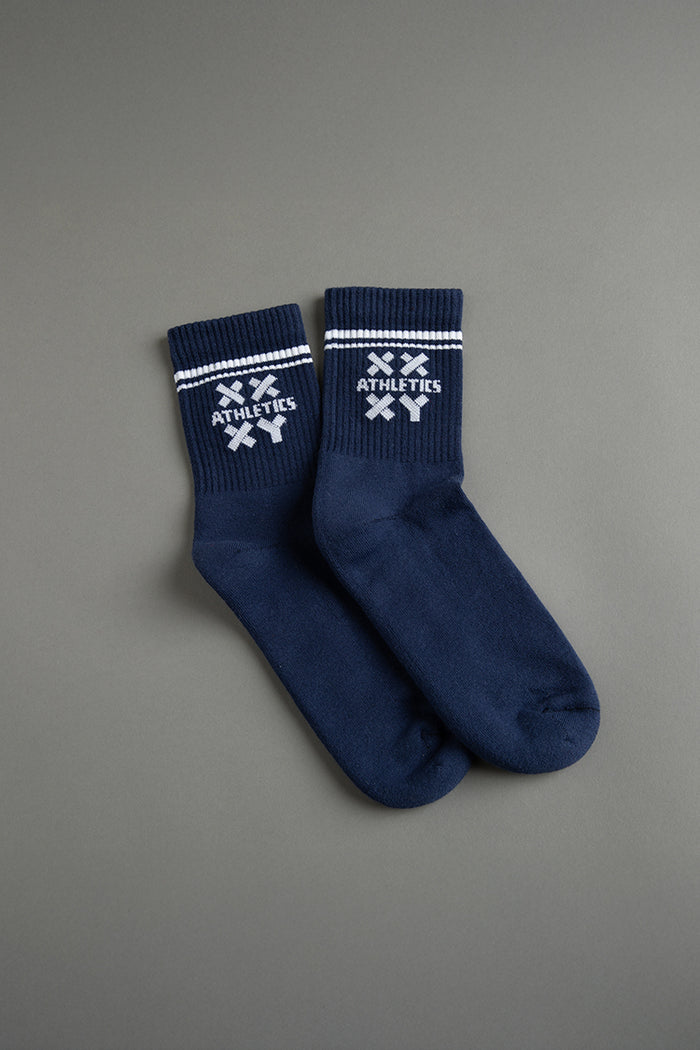 Pair of navy blue socks with white accents on a gray background || navy