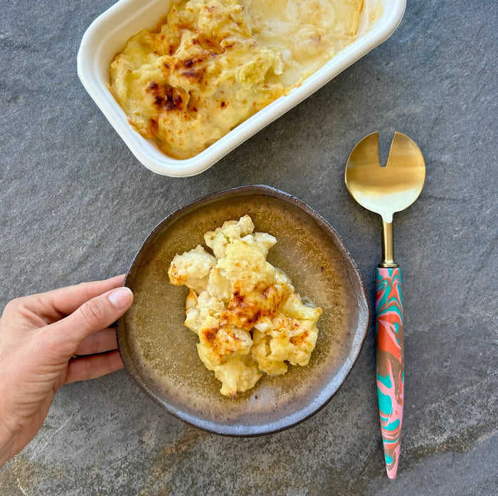 Cauliflower Cheese served in a handmade soft brown rustic bowl