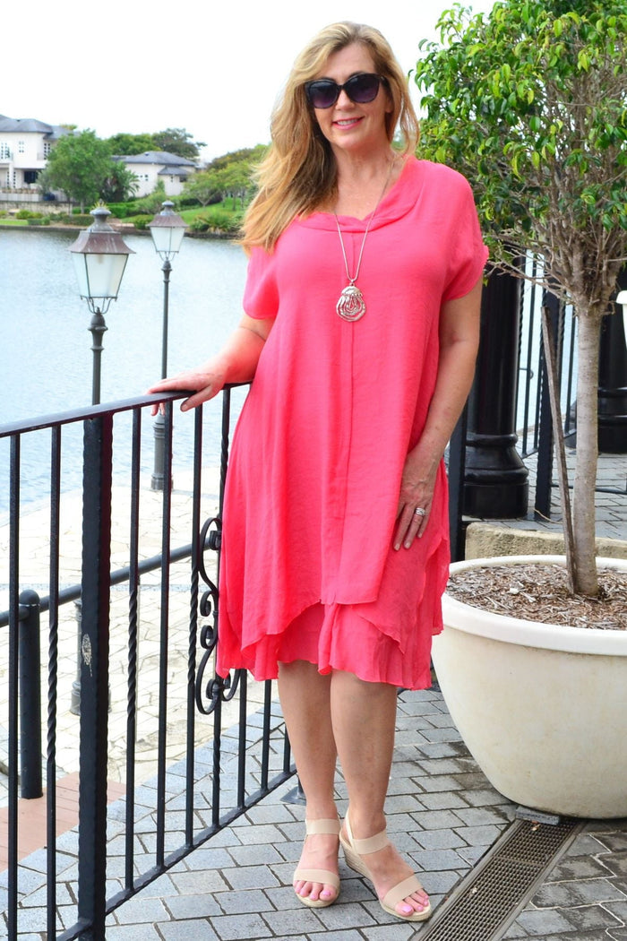 Wishstone coral drop shoulder tunic dress hanging on a hanger, showcasing the relaxed fit and vibrant color.