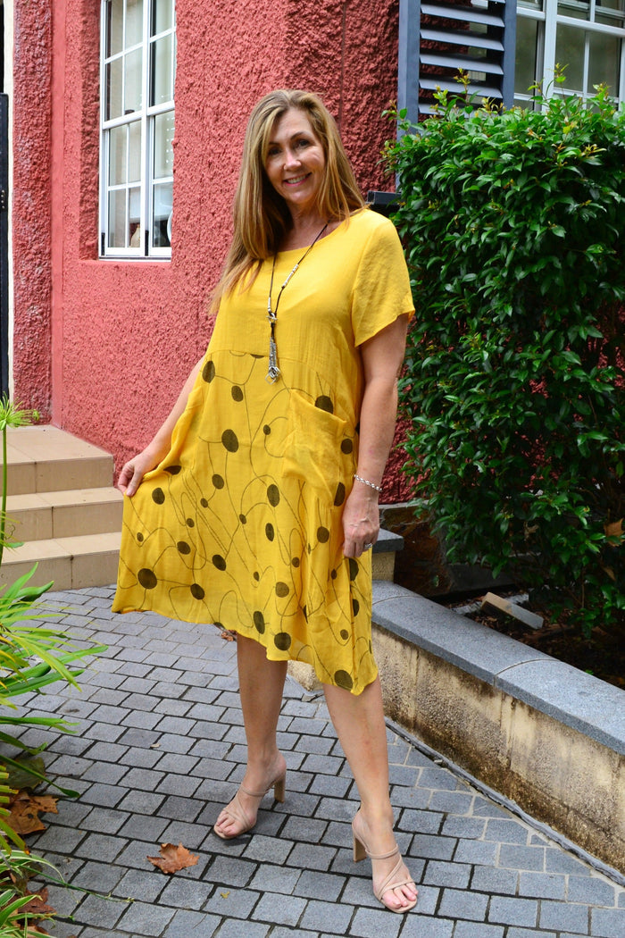 Bright yellow Wishstone Dotty Pocket Dress tunic with short sleeves and a relaxed fit, featuring playful polka dot pattern and front pockets.