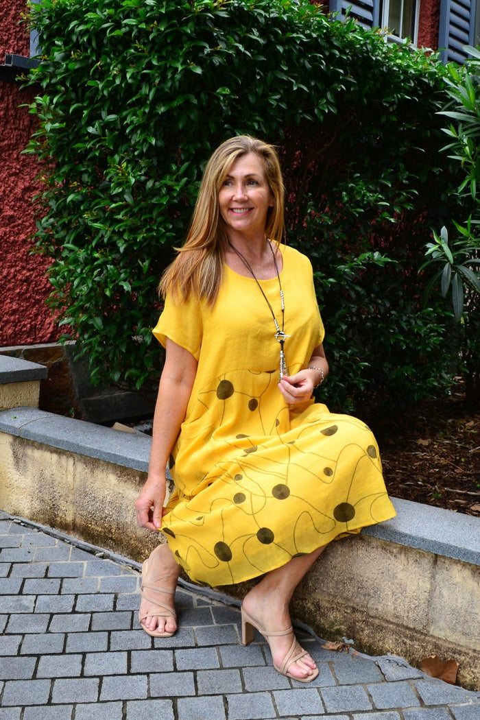 Wishstone Dotty Yellow Pocket Dress Tunic displayed on a hanger, featuring a bright yellow fabric with playful dot pattern and side pockets.