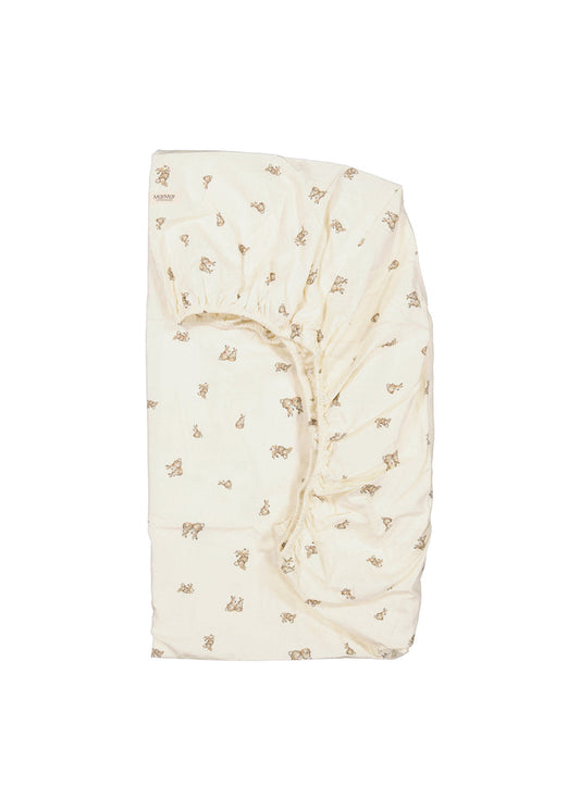 Foldet cremet lagen med elastik i hjørne og små dyremotiver