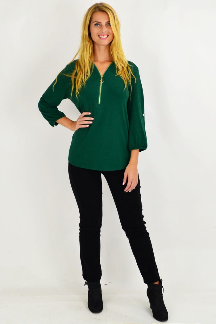 Green Envogo Amelia Tunic featuring a relaxed fit with long sleeves and a round neckline, displayed on a hanger.