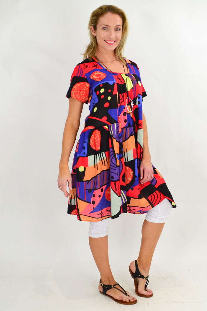 Colorful Ken Done inspired peasant tunic dress by Hourglass, featuring loose fit and vibrant floral patterns, front view.