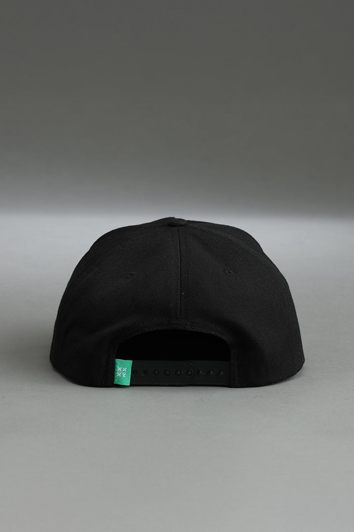 Black cap with a green label on a gray background || black