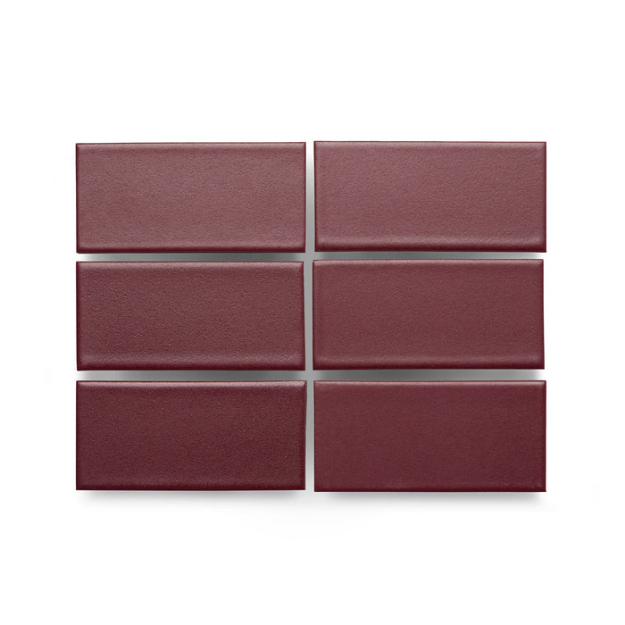 Six Heath Ceramics ceramic tiles glazed in Cranberry, a matte saturated burgundy-red glaze