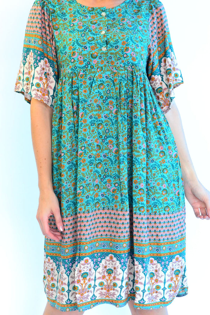 Bohemian green Persian Palace bell sleeve tunic dress by Hourglass, featuring intricate patterns and flowing fabric.