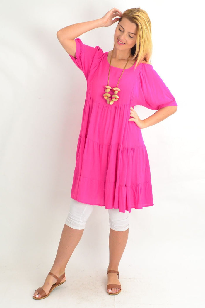 Pink Willow Tree tiered tunic dress with a flowy, layered design, showcased on a hanger against a neutral background.