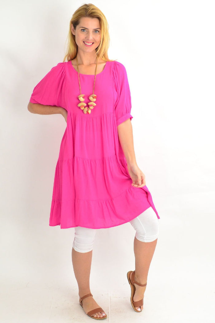 Pink Willow Tree tiered tunic dress with ruffled layers and long sleeves, displayed on a hanger against a plain background.