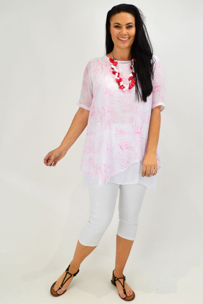 Pink leaf-patterned tunic top by Whispers with a relaxed fit and long sleeves, displayed on a hanger.