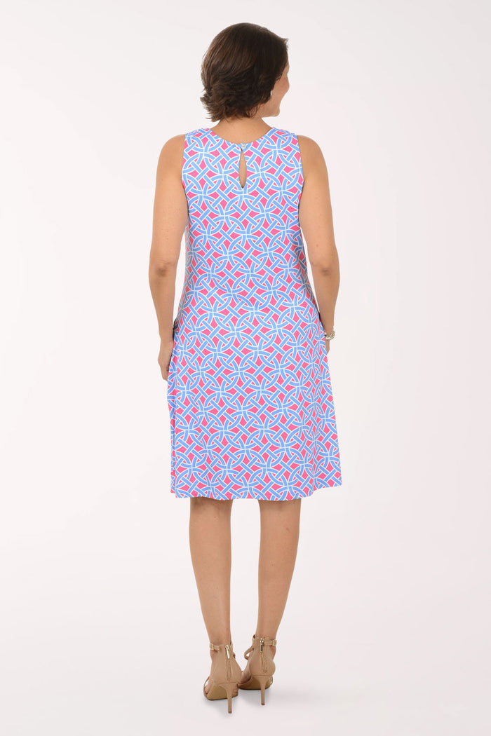 Woman wearing a sleeveless dress with a pattern on a white background
