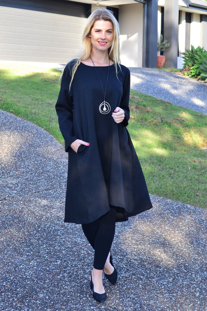 Relaxed black textured tunic dress by Poney, showcasing a loose fit and stylish fabric detail on a model.