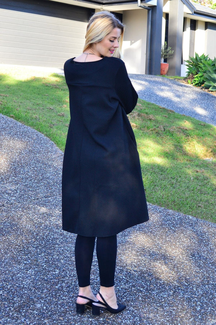 Relaxed black textured tunic dress by Poney, featuring a flowy silhouette and subtle textured fabric.