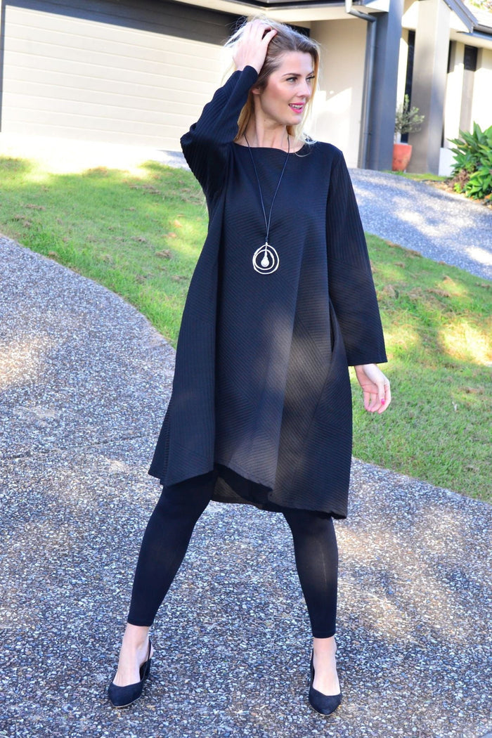 Relaxed black textured tunic dress by Poney, featuring a loose fit and subtle fabric texture, styled on a model.
