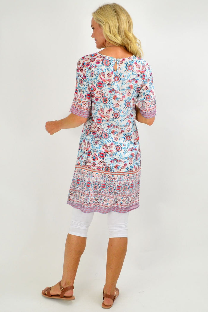 Orientique Ronda Shift Tunic Dress with floral pattern, relaxed fit, and vibrant colors, displayed on a hanger.