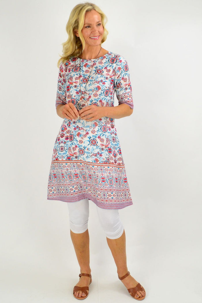 Orientique Ronda Shift Tunic Dress hanging on a hanger, showcasing its relaxed fit and vibrant pattern.