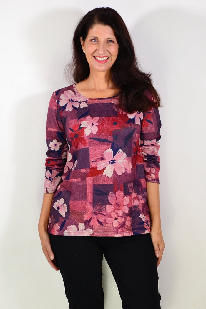 Salmon pink floral print tunic top from Hourglass, featuring a flowy design and vibrant flower pattern displayed on the front.