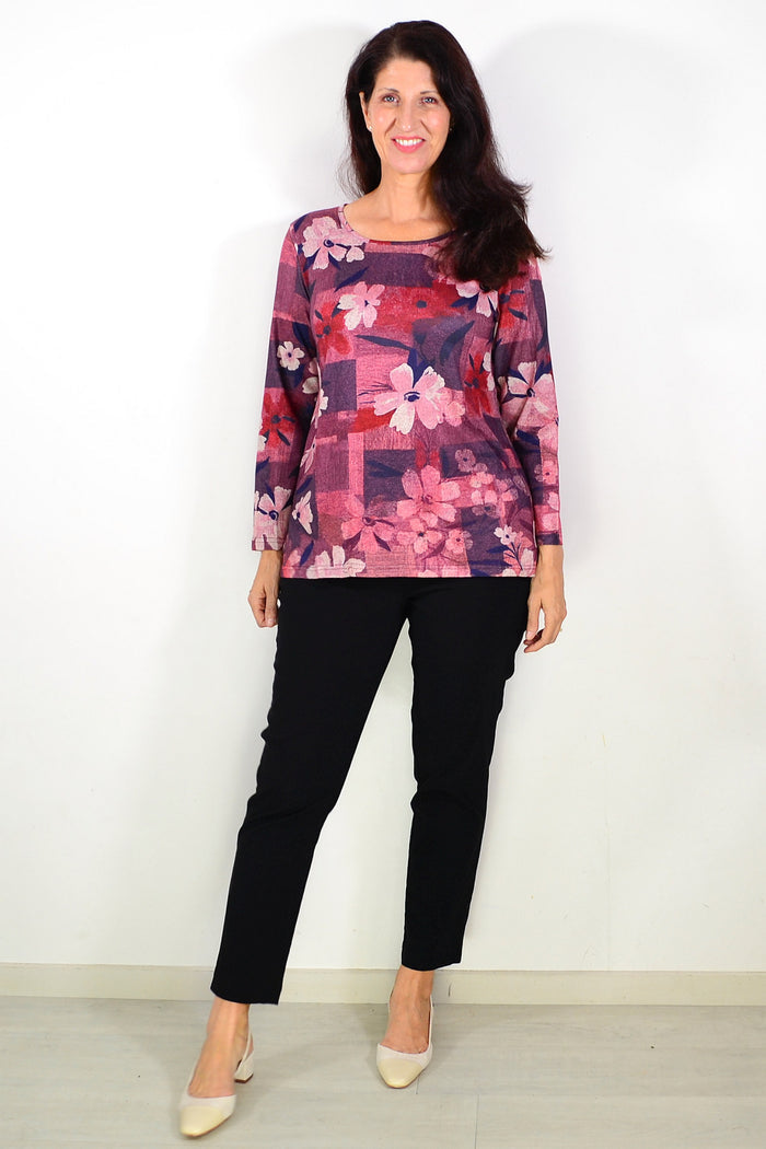 Salmon pink floral print tunic top by Hourglass with long sleeves and relaxed fit, displayed on a hanger.