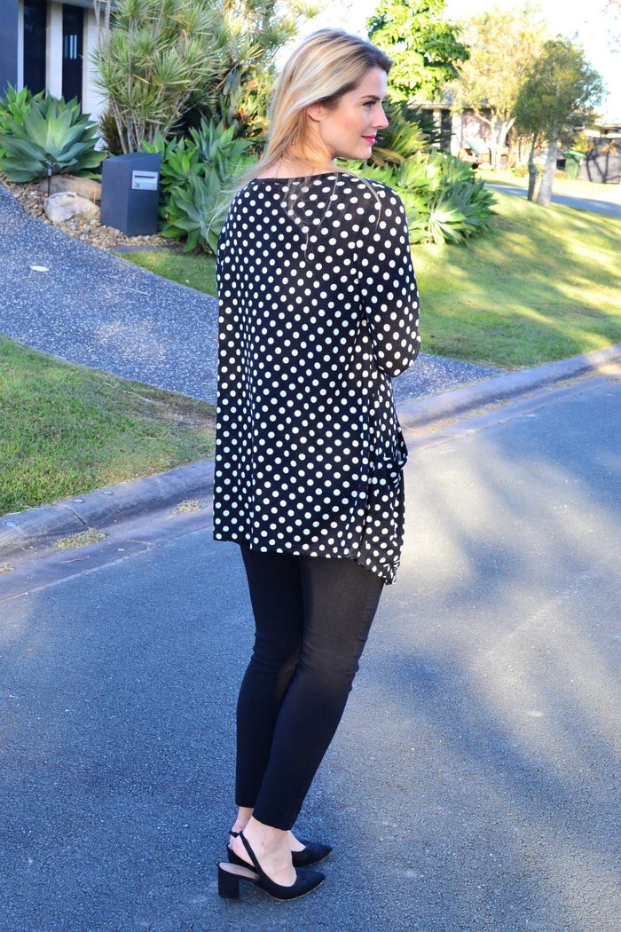 White and black pockets and dots winter tunic top by Peony, featuring a cozy, stylish design with button details and long sleeves.